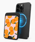Orange Fruit on Pink MagSafe card holder attached to a compatible iPhone