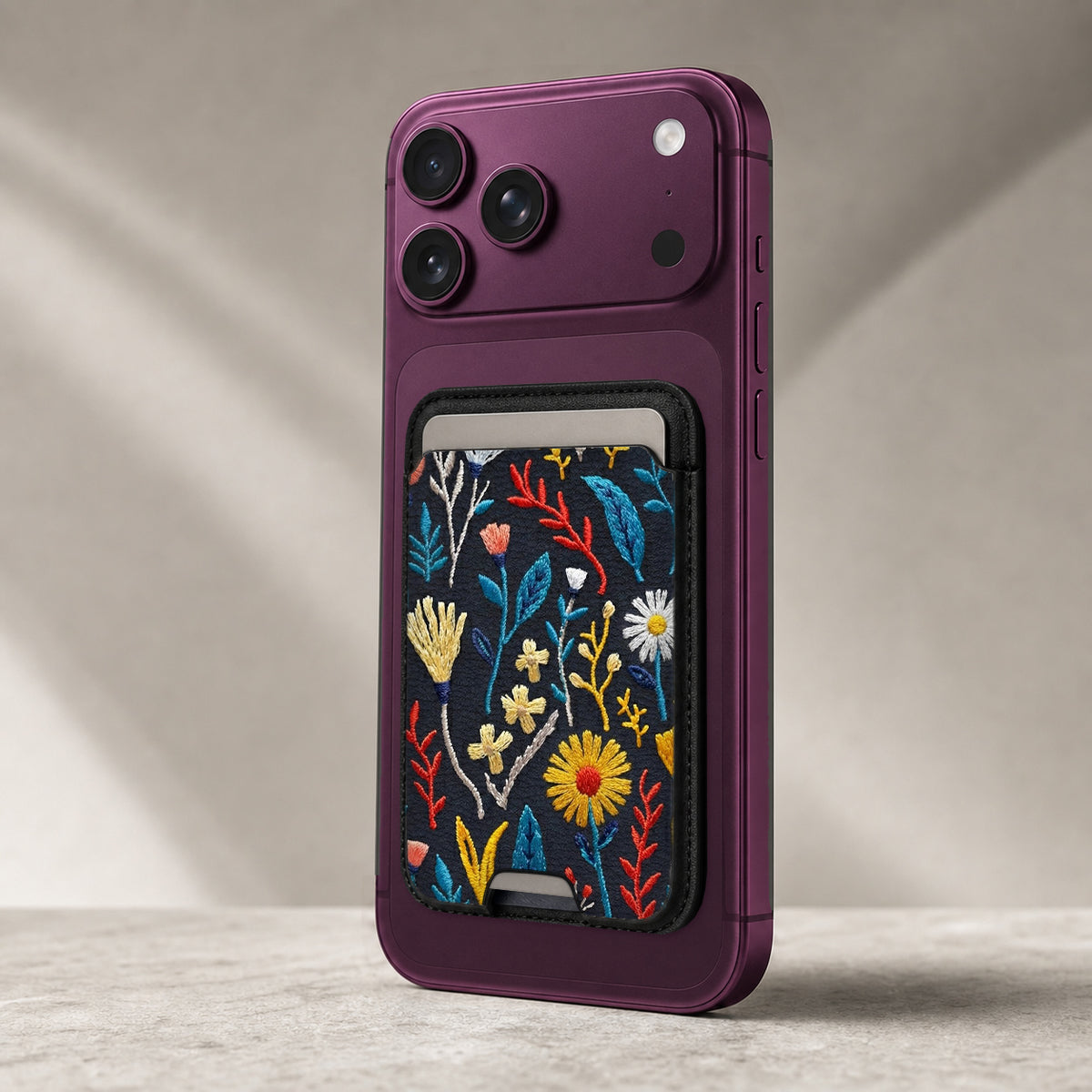 Navy Embroidered Wildflower MagSafe card holder showing the detailed leather finish