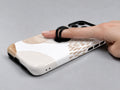Beige Abstract Pebble MagSafe Loop iPhone Case shown in use with a finger through the horizontal loop