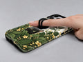 Black Cat Botanical Garden MagSafe Loop iPhone Case, shown in use with a finger through the loop