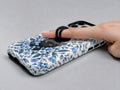 Black Cat in Blue Botanical Flowers MagSafe Loop Case, shown with a finger through the loop
