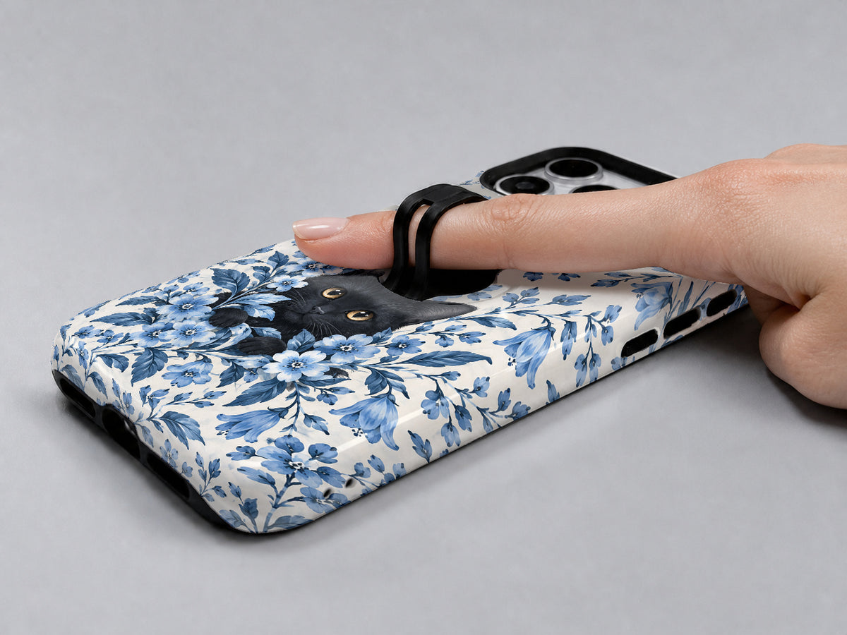 Black Cat in Blue Botanical Flowers MagSafe Loop Case, shown with a finger through the loop