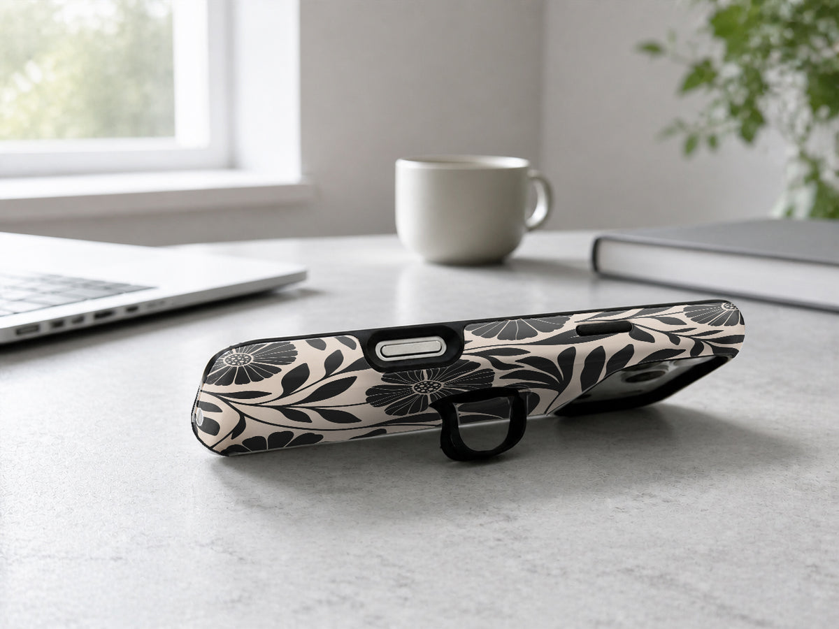 Black Cream Bold Floral MagSafe Loop iPhone Case shown in a neutral white professional lifestyle setting