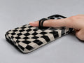 Black Cream Wavy Checkerboard MagSafe Loop iPhone Case shown in use with a finger through the horizontal loop