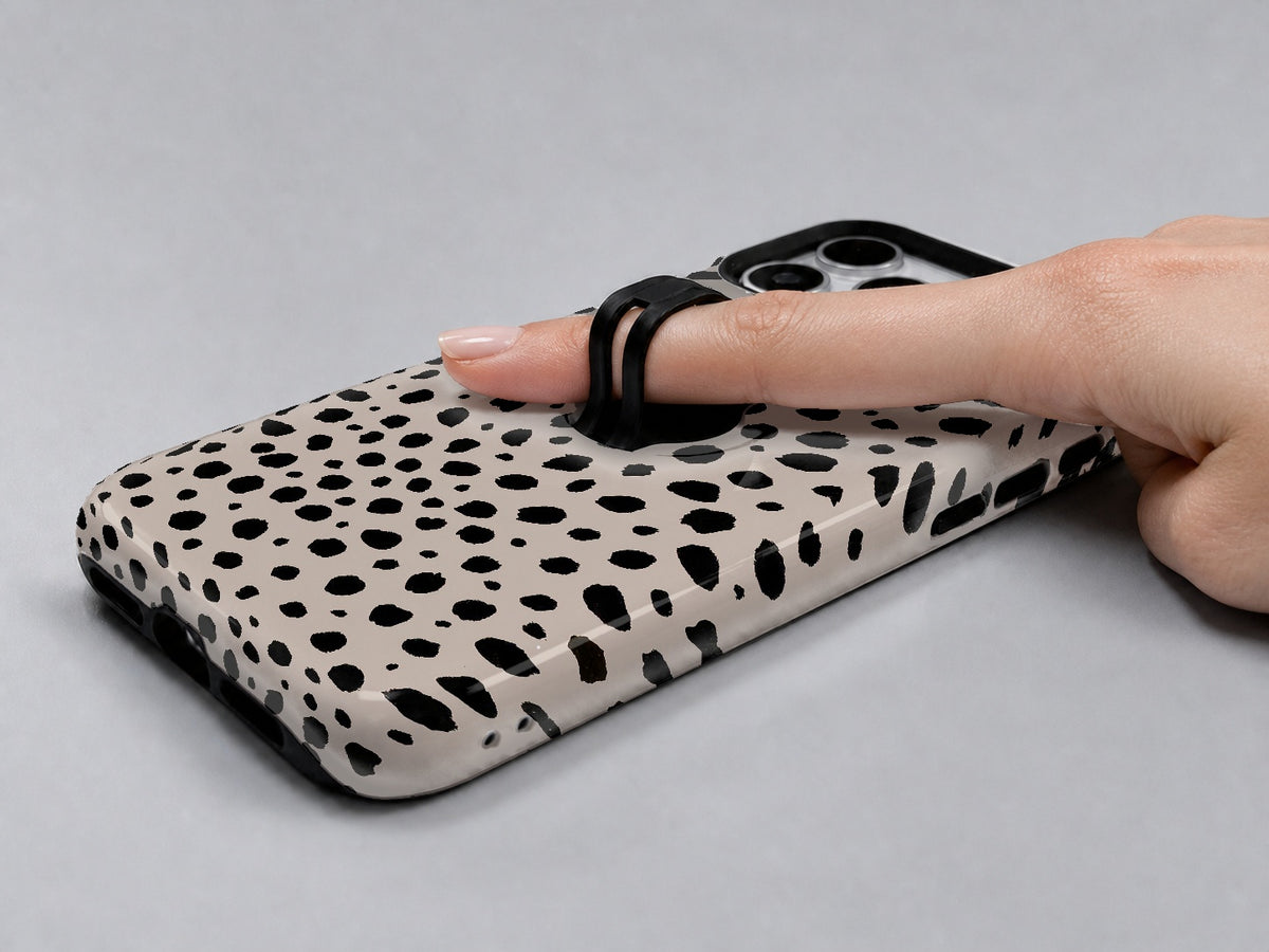 Black Dalmatian Spot MagSafe Loop iPhone Case shown in use with a finger through the horizontal loop