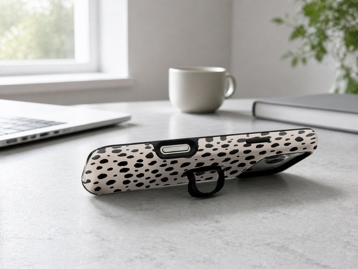 Black Dalmatian Spot MagSafe Loop iPhone Case shown in a neutral white professional lifestyle setting