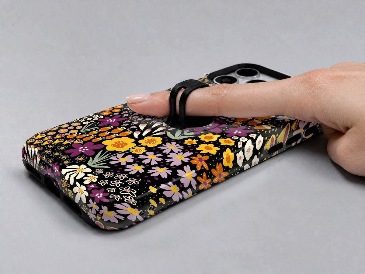 Black Folk Garden Floral MagSafe Loop iPhone Case shown in use with a finger through the horizontal loop