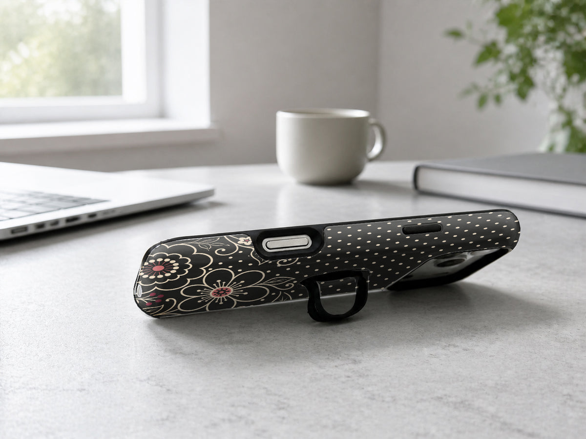 Black Pink Henna Floral MagSafe Loop iPhone Case shown in a neutral white professional lifestyle setting