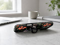 Black Wildflower Meadow MagSafe Loop iPhone Case shown in a neutral white professional lifestyle setting