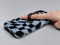 Blue Black Wavy Checkerboard MagSafe Loop iPhone Case shown in use with a finger through the horizontal loop