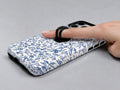 Blue Chinoiserie Floral MagSafe Loop iPhone Case shown in use with a finger through the horizontal loop