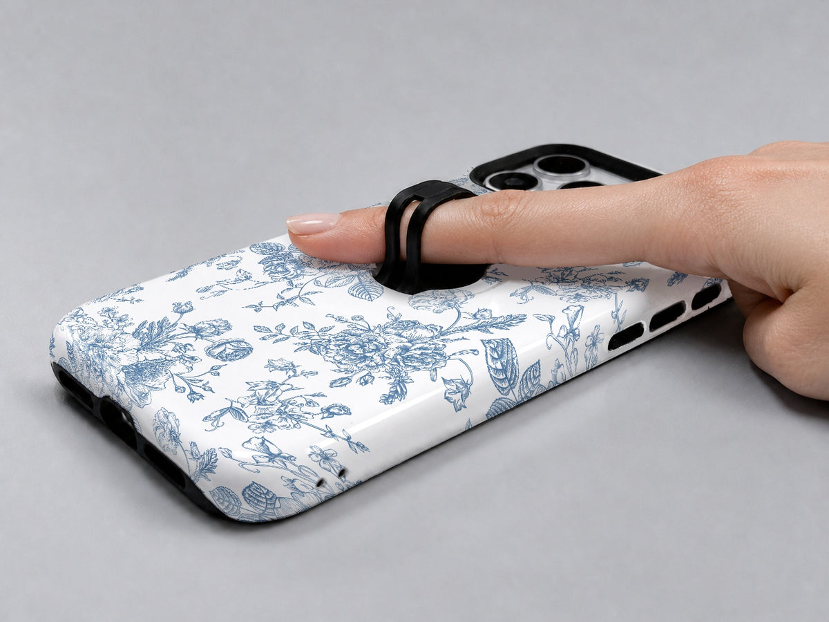 Blue Chinoiserie Rose MagSafe Loop iPhone Case shown in use with a finger through the horizontal loop