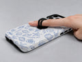 Blue Coastal Seashell MagSafe Loop iPhone Case shown in use with a finger through the horizontal loop