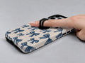 Blue Coquette Bow MagSafe Loop iPhone Case shown in use with a finger through the horizontal loop