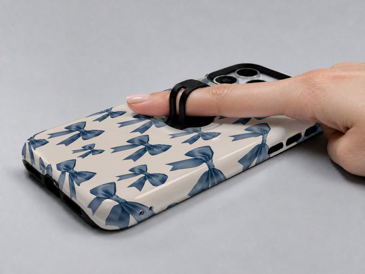 Blue Coquette Bow MagSafe Loop iPhone Case shown in use with a finger through the horizontal loop