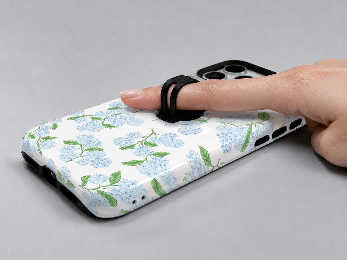 Blue Hydrangea Botanical MagSafe Loop iPhone Case shown in use with a finger through the horizontal loop