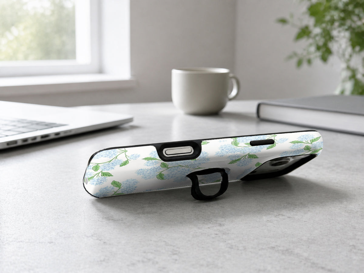 Blue Hydrangea Botanical MagSafe Loop iPhone Case shown in a neutral white professional lifestyle setting