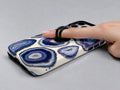 Blue Purple Agate Geode MagSafe Loop iPhone Case shown in use with a finger through the horizontal loop
