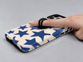 Blue Star Pattern MagSafe Loop iPhone Case shown in use with a finger through the horizontal loop