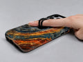 Blue Tiger Eye Stone MagSafe Loop iPhone Case shown in use with a finger through the horizontal loop