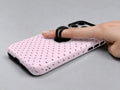 Blush Pink Mini Polka Dot MagSafe Loop iPhone Case shown in use with a finger through the horizontal loop