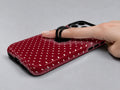 Burgundy Mini Polka Dot MagSafe Loop iPhone Case shown in use with a finger through the horizontal loop