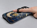 Celestial Sun Moon Compass MagSafe Loop iPhone Case shown in use with a finger through the horizontal loop