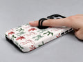 Christmas Bow and Mistletoe MagSafe Loop iPhone Case shown in use with a finger through the horizontal loop