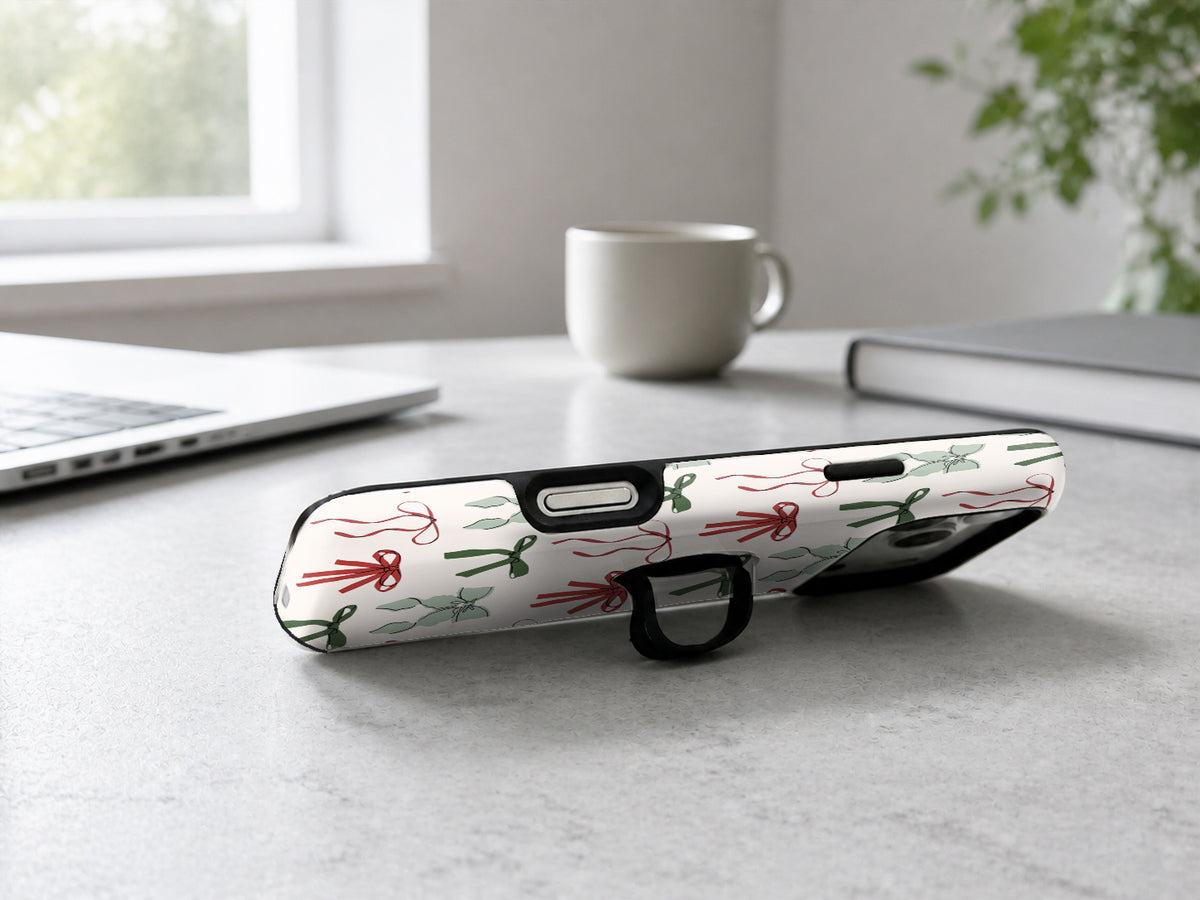Christmas Bow and Mistletoe MagSafe Loop iPhone Case shown in a neutral white professional lifestyle setting