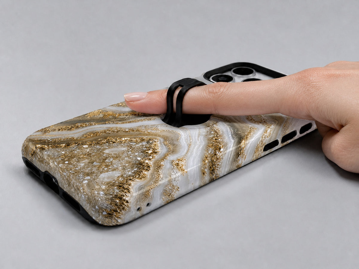 Cream Gold Geode Marble MagSafe Loop iPhone Case shown in use with a finger through the horizontal loop