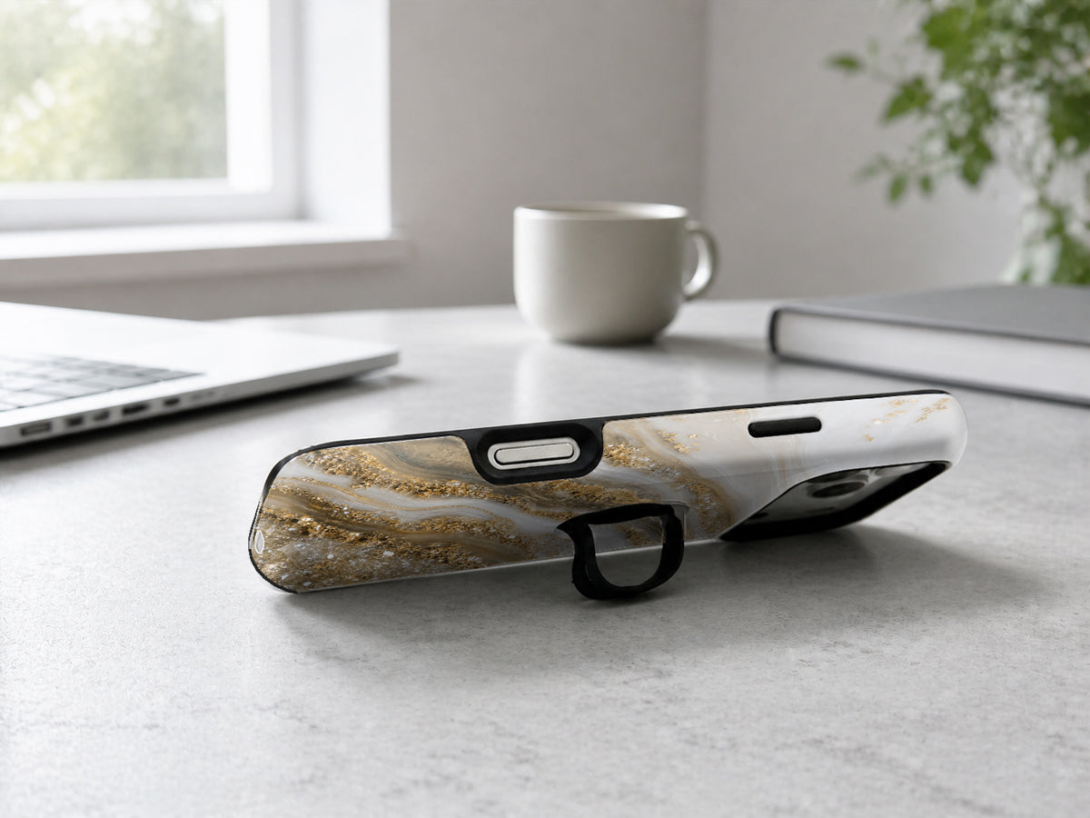 Cream Gold Geode Marble MagSafe Loop iPhone Case shown in a neutral white professional lifestyle setting