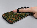 Dark Arts and Crafts Floral MagSafe Loop iPhone Case shown in use with a finger through the horizontal loop