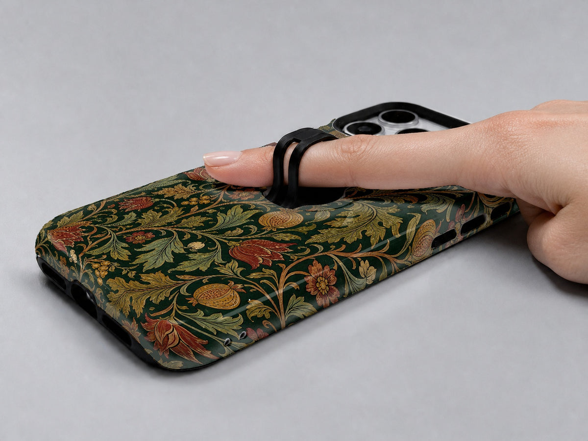 Dark Arts and Crafts Floral MagSafe Loop iPhone Case shown in use with a finger through the horizontal loop
