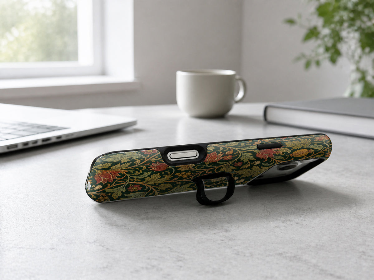Dark Arts and Crafts Floral MagSafe Loop iPhone Case shown in a neutral white professional lifestyle setting