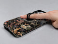 Dark Cottage Garden Floral MagSafe Loop iPhone Case shown in use with a finger through the horizontal loop