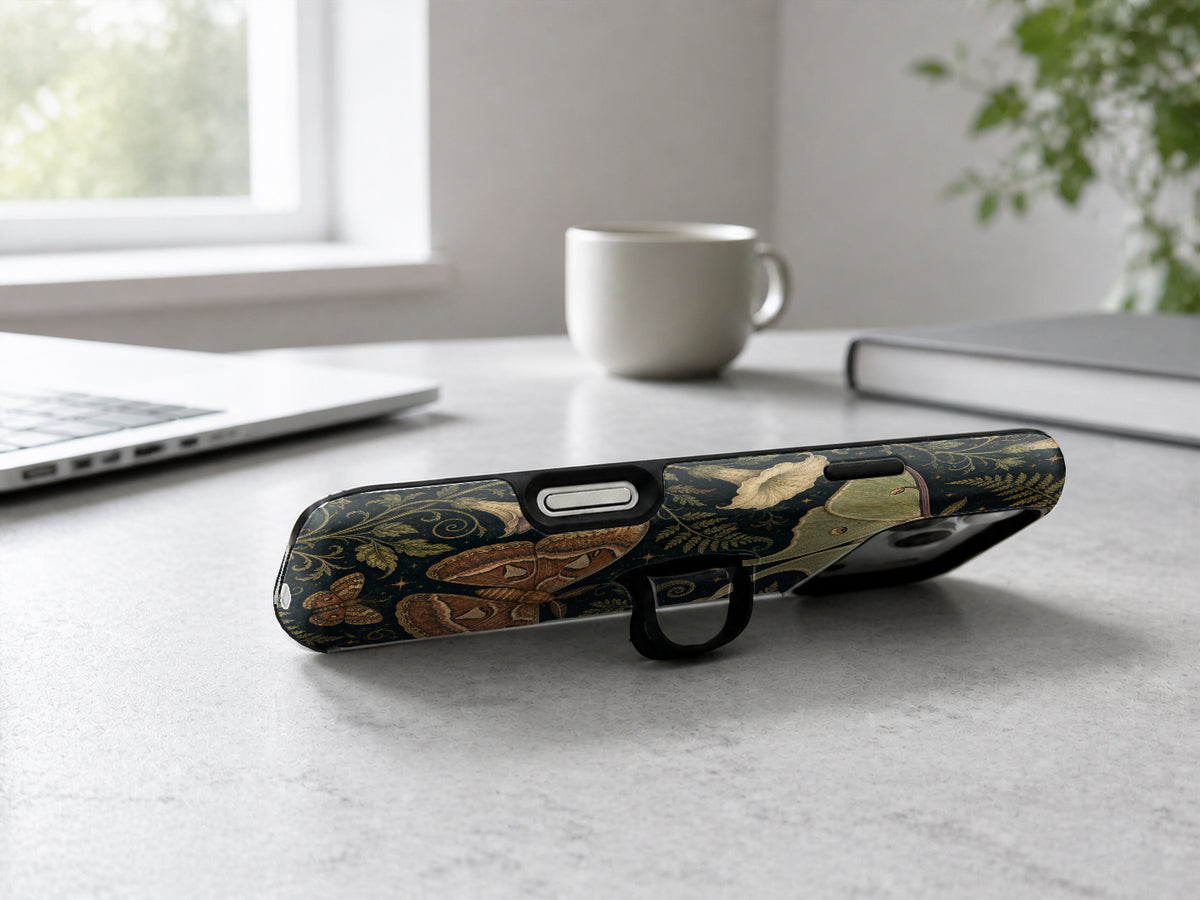 Dark Moth Botanical MagSafe Loop iPhone Case shown in a neutral white professional lifestyle setting