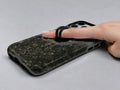 Dark Vintage Botanical MagSafe Loop iPhone Case shown in use with a finger through the horizontal loop