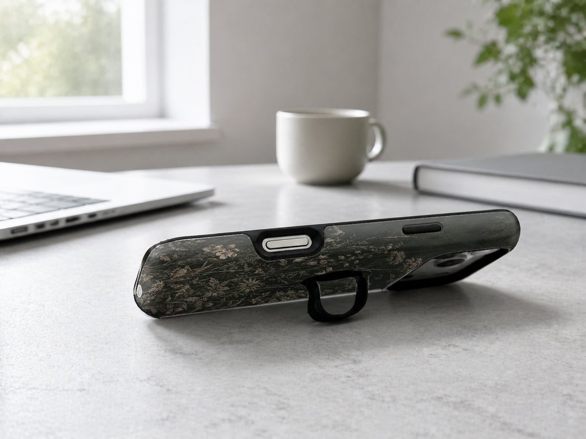Dark Vintage Botanical MagSafe Loop iPhone Case shown in a neutral white professional lifestyle setting