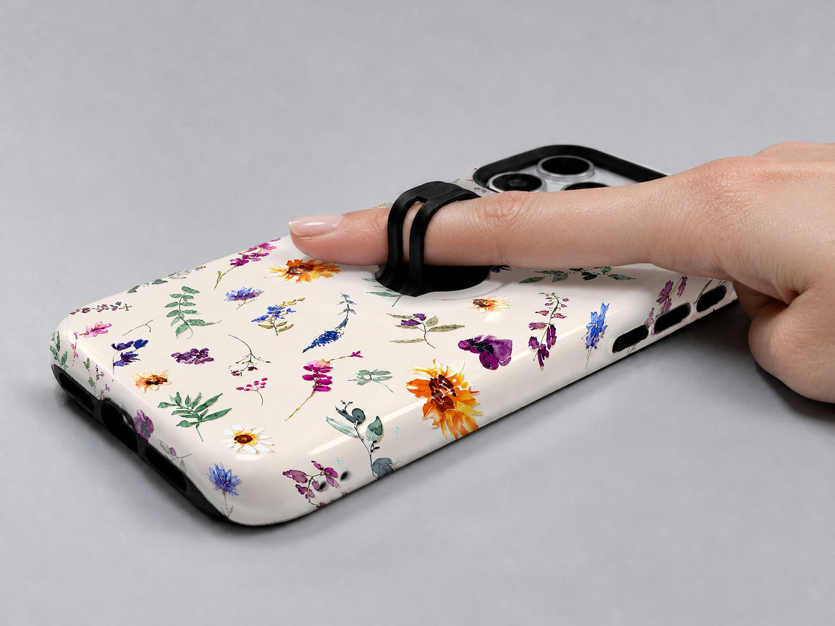 Delicate Mixed Wildflower MagSafe Loop iPhone Case shown in use with a finger through the horizontal loop