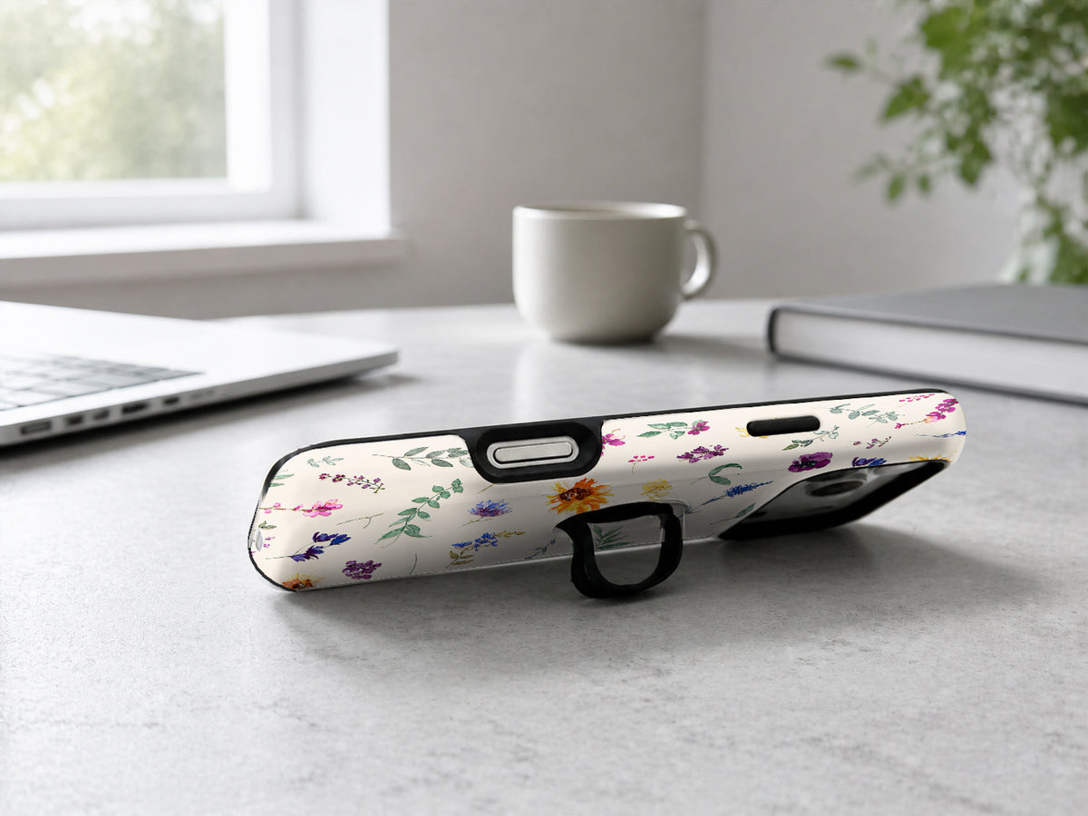 Delicate Mixed Wildflower MagSafe Loop iPhone Case shown in a neutral white professional lifestyle setting