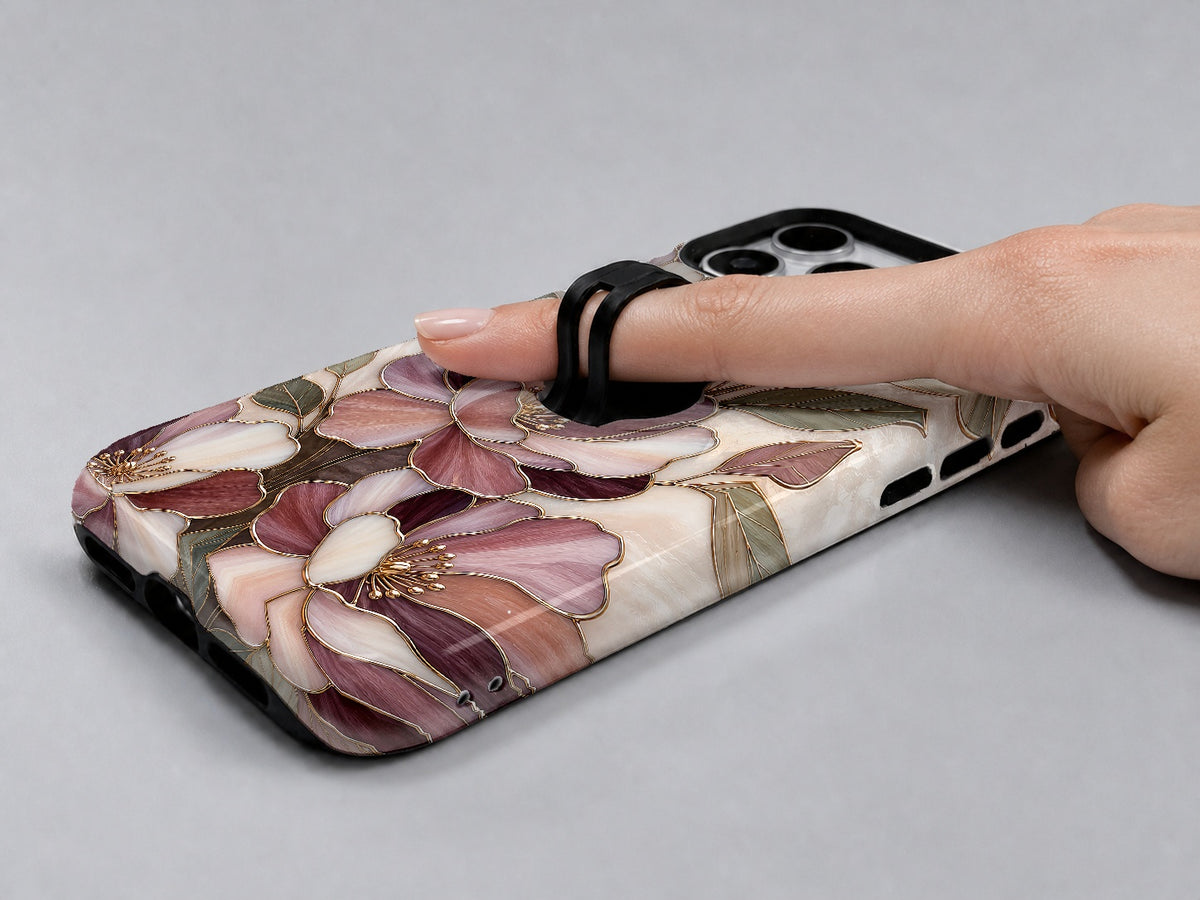 Dusty Rose Magnolia Floral MagSafe Loop iPhone Case shown in use with a finger through the horizontal loop