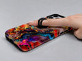 Fiery Agate Marble MagSafe Loop iPhone Case shown in use with a finger through the horizontal loop
