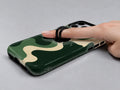 Forest Green Abstract Wave MagSafe Loop iPhone Case shown in use with a finger through the horizontal loop