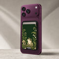 Forest Green Frog and Mushroom Garden MagSafe Card Holder, attached to the back of a compatible phone