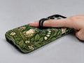Forest Green Frog and Mushroom Garden MagSafe Loop iPhone Case, shown in use with a finger through the loop