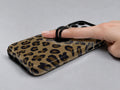 Golden Leopard Print MagSafe Loop iPhone Case shown in use with a finger through the horizontal loop