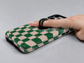 Green Cream Checkerboard MagSafe Loop iPhone Case shown in use with a finger through the horizontal loop