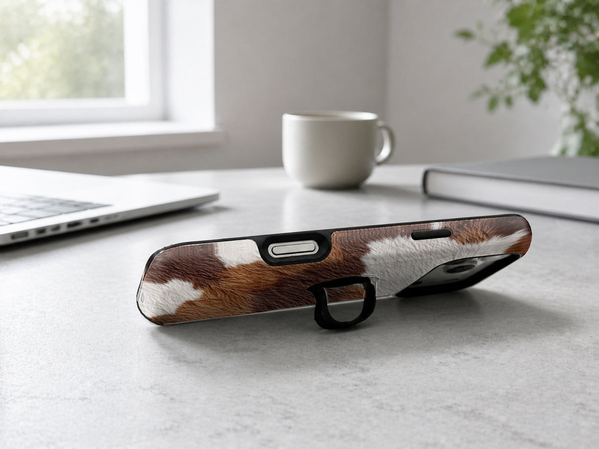 Highland Cowhide Print MagSafe Loop iPhone Case shown in a neutral white professional lifestyle setting