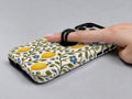 Lemon Botanical MagSafe Loop iPhone Case shown in use with a finger through the horizontal loop