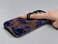 Midnight Purple Floral MagSafe Loop iPhone Case shown in use with a finger through the horizontal loop